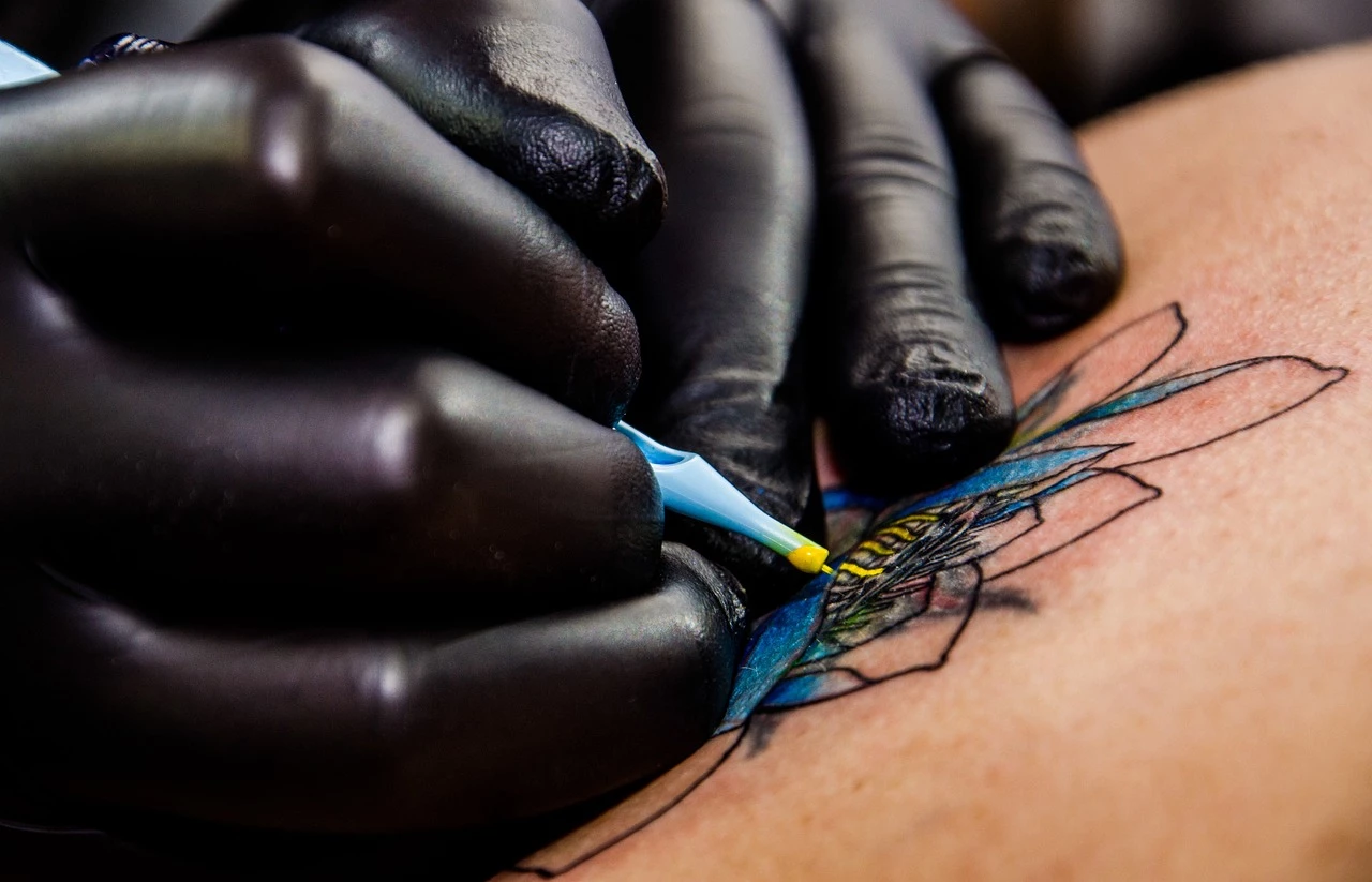 Hände mit Tattoo Maschine tätowieren auf Haut